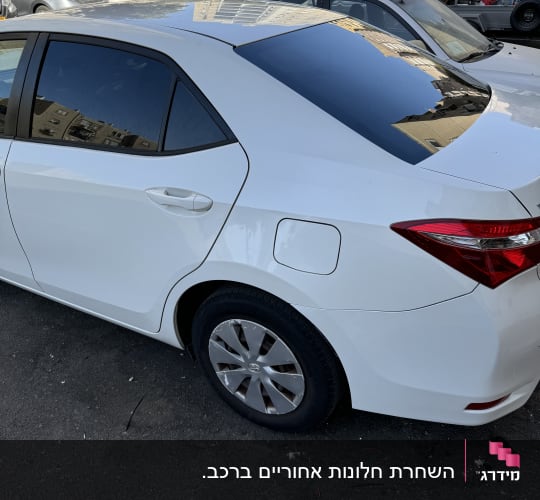 מכונית לבנה עם חלונות כהים בחניה